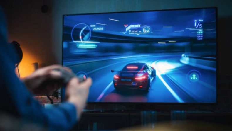 A Man playing a car race video game.